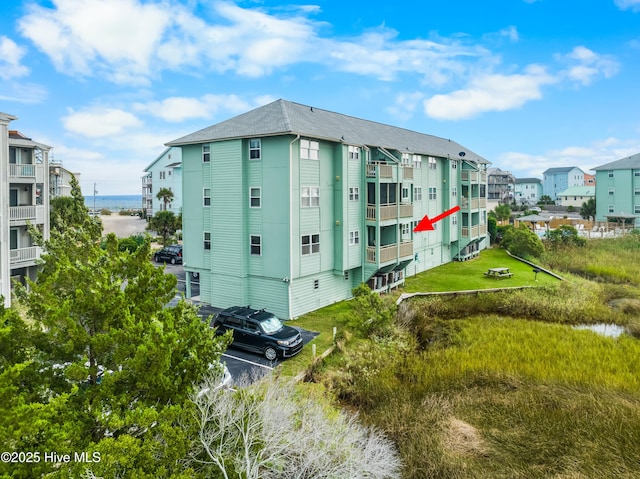 view of building exterior featuring uncovered parking and a residential view