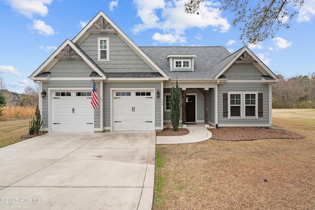 craftsman house with a garage, concrete driveway, roof with shingles, and a front yard