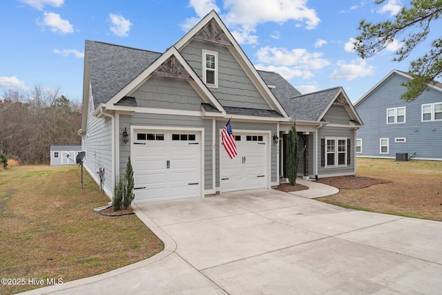 view of front of home featuring driveway, an attached garage, a front lawn, and roof with shingles