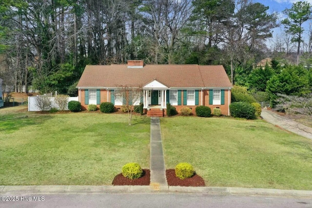 view of front of house featuring crawl space, brick siding, a chimney, and a front lawn