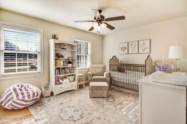 bedroom featuring multiple windows, wood finished floors, and a ceiling fan