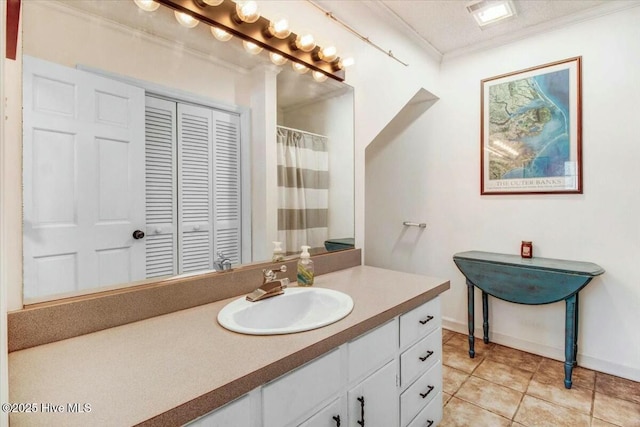 bathroom with tile patterned flooring, vanity, baseboards, a closet, and crown molding