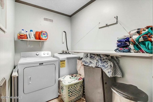 laundry room featuring laundry area, crown molding, washer and clothes dryer, and a textured ceiling