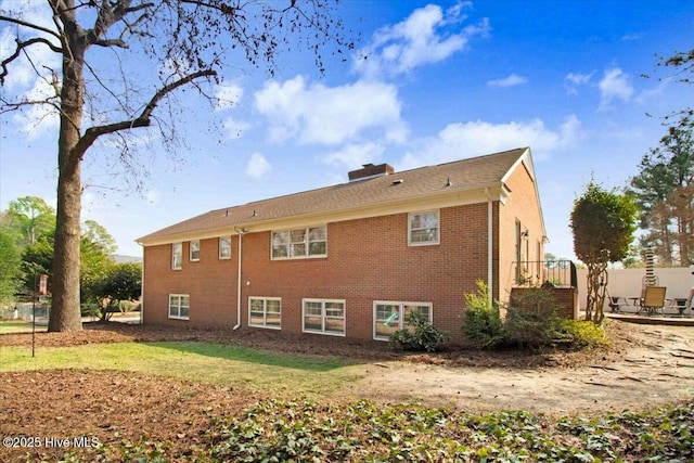 rear view of property with brick siding