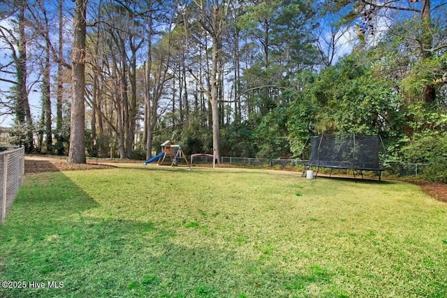 view of yard with a fenced backyard, a trampoline, and playground community