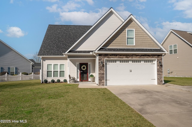 craftsman inspired home with driveway, roof with shingles, fence, and a front yard