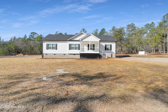 view of front of home featuring covered porch, a shingled roof, and crawl space