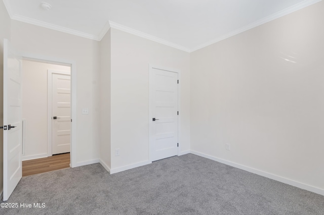 unfurnished bedroom with ornamental molding, carpet floors, and baseboards