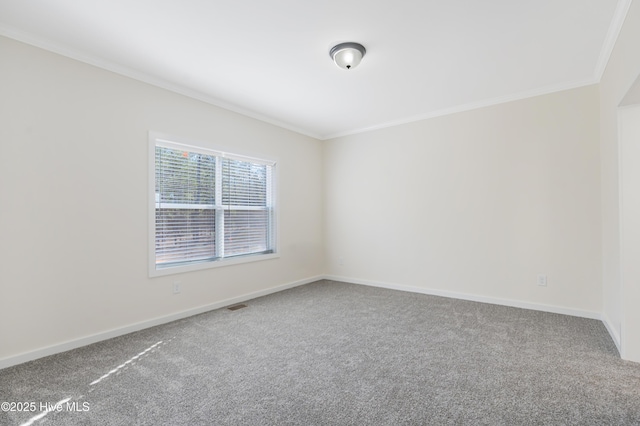 carpeted empty room with ornamental molding, visible vents, and baseboards