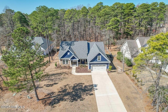 view of front of house featuring driveway and a forest view