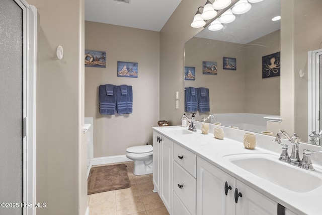 full bath featuring toilet, tile patterned flooring, double vanity, and a sink