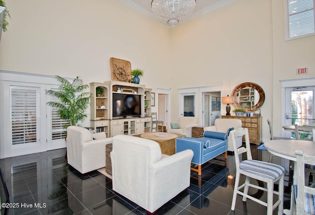 living area featuring a high ceiling, ornamental molding, a wealth of natural light, and dark tile patterned flooring