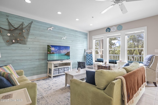 living room featuring recessed lighting, ceiling fan, wooden walls, and light tile patterned floors