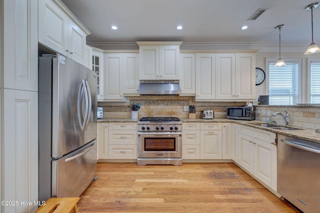 kitchen with stainless steel appliances, a sink, visible vents, ornamental molding, and ventilation hood