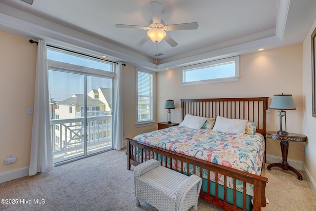 carpeted bedroom featuring access to exterior, a tray ceiling, visible vents, a ceiling fan, and baseboards