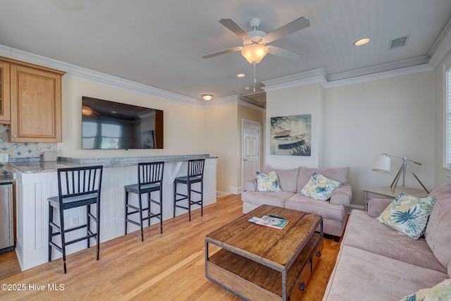 living room featuring crown molding, recessed lighting, visible vents, light wood-style flooring, and a ceiling fan