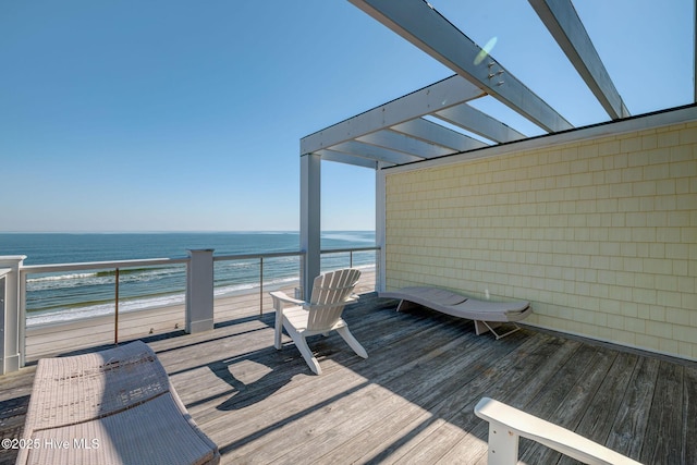 wooden terrace with a water view and a view of the beach