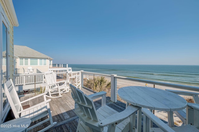 balcony featuring a water view and a beach view