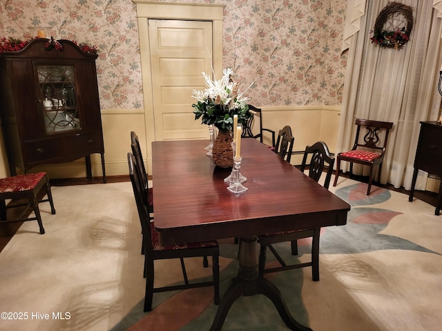 dining space with wallpapered walls and wainscoting