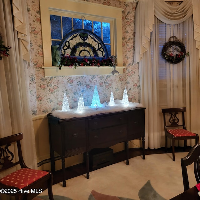 living area featuring a wainscoted wall, carpet, and wallpapered walls