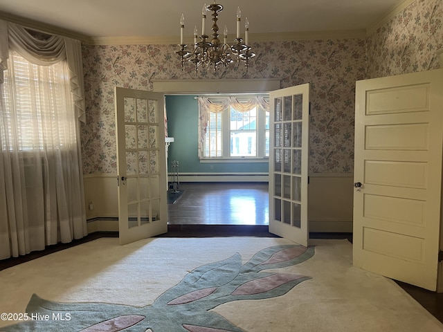 dining space featuring french doors, wainscoting, crown molding, and wallpapered walls