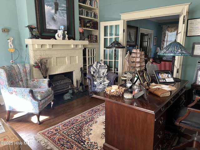 home office with a fireplace and wood finished floors