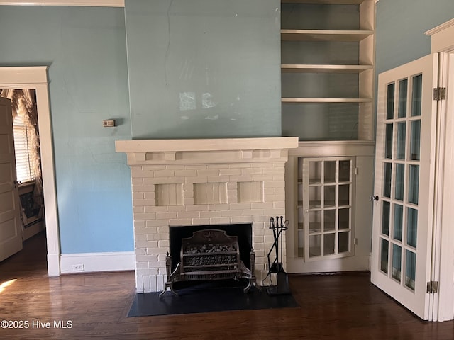 unfurnished living room with a fireplace, baseboards, and wood finished floors