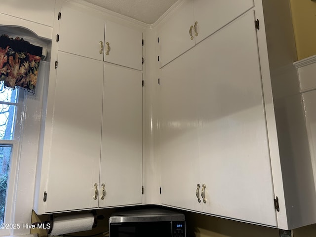 interior details featuring white cabinets and stainless steel microwave