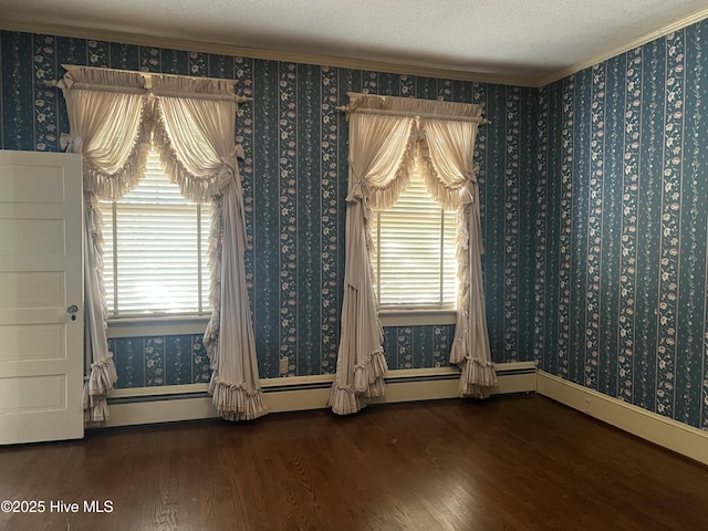 unfurnished dining area featuring a textured ceiling, a baseboard heating unit, wood finished floors, wallpapered walls, and crown molding