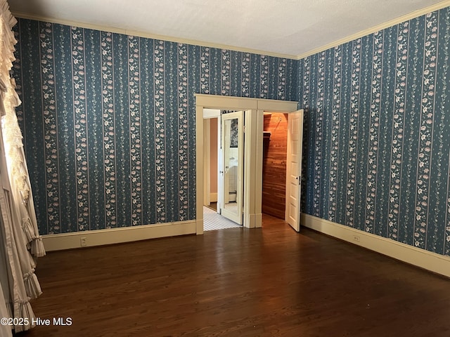 unfurnished room with wallpapered walls, baseboards, ornamental molding, and wood finished floors