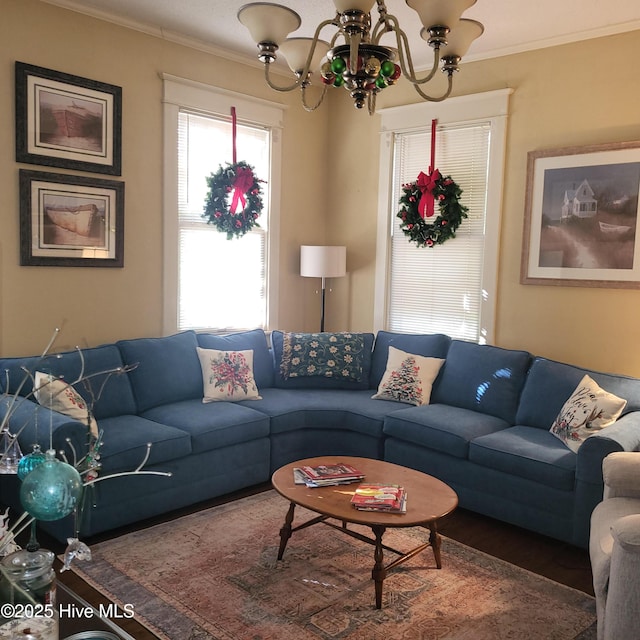 living room with crown molding, a notable chandelier, and wood finished floors