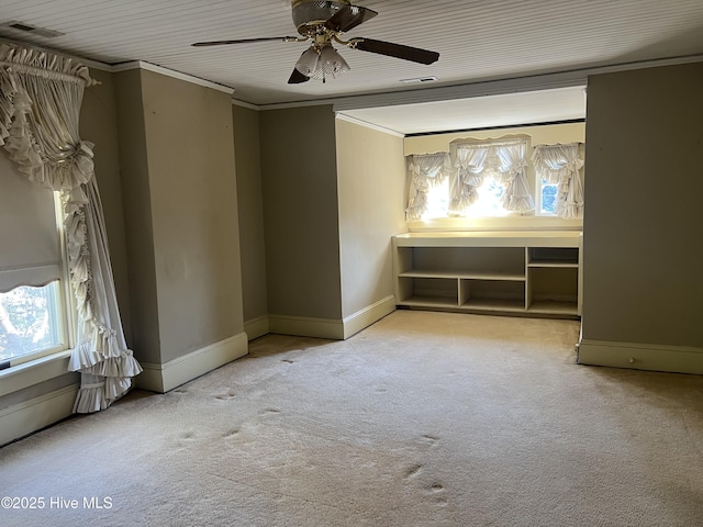 unfurnished room featuring ornamental molding, carpet flooring, visible vents, and baseboards