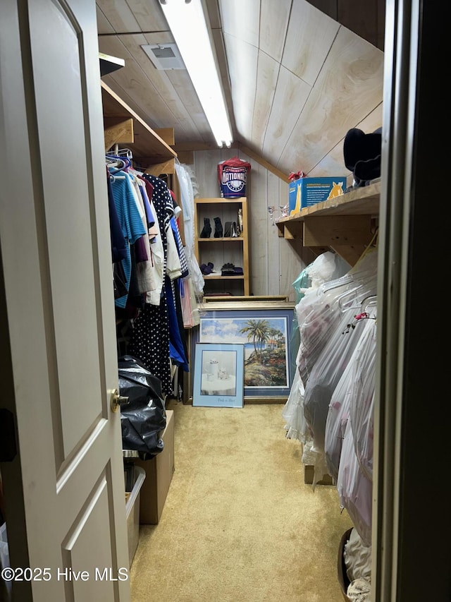 walk in closet with lofted ceiling and carpet