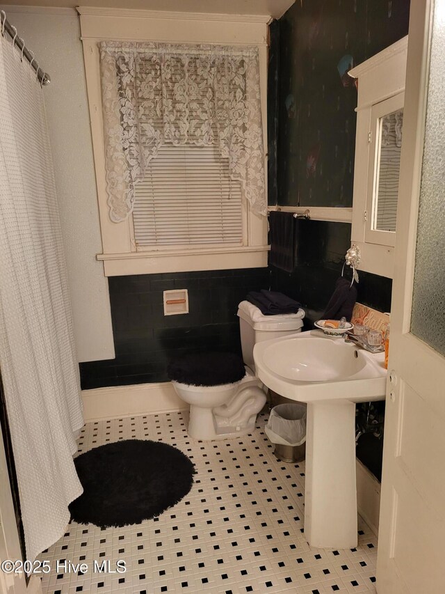 bathroom with toilet and tile patterned flooring