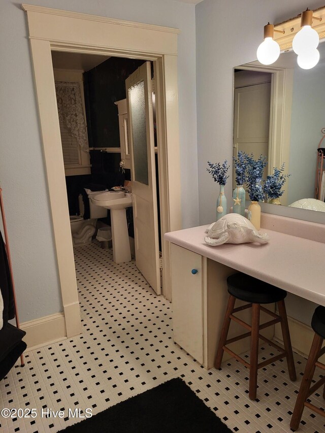 bathroom featuring baseboards and a sink