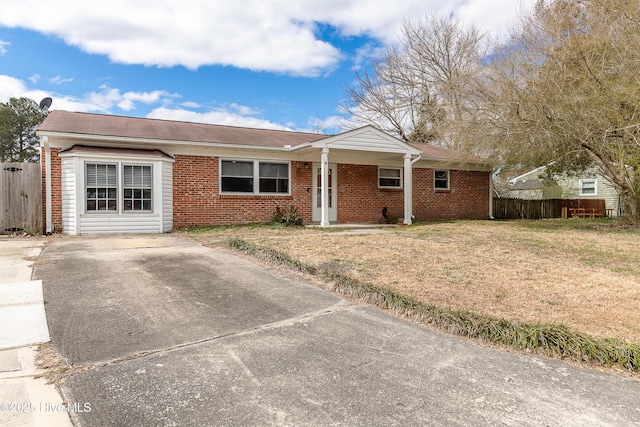 ranch-style home featuring a front yard, brick siding, and fence