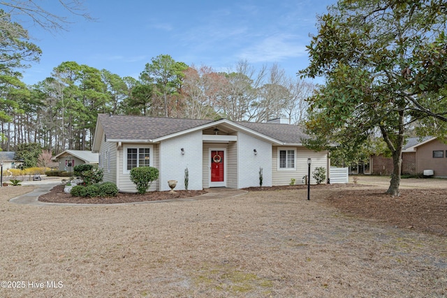 view of front facade featuring a shingled roof and brick siding