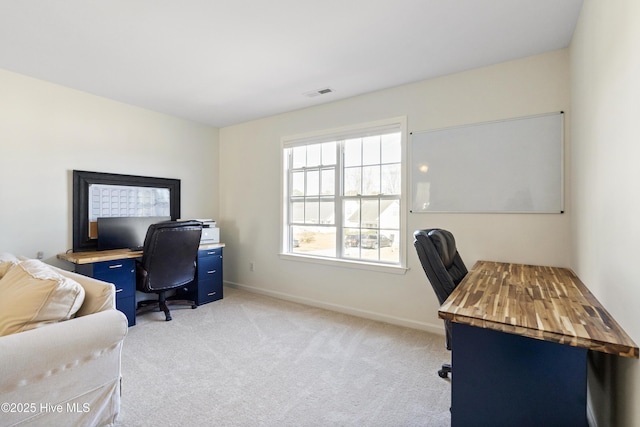 home office featuring light colored carpet, visible vents, and baseboards