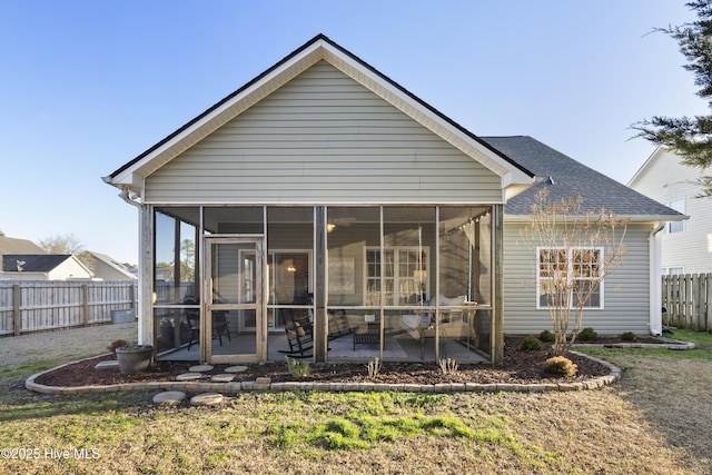 back of house with a sunroom, a shingled roof, and fence