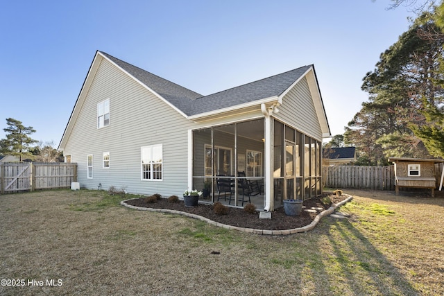 rear view of property with roof with shingles, a lawn, fence, and a sunroom