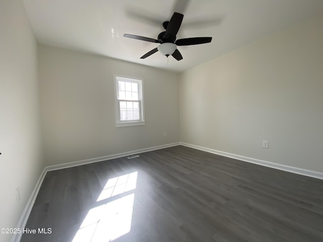 empty room with dark wood-style floors, ceiling fan, and baseboards