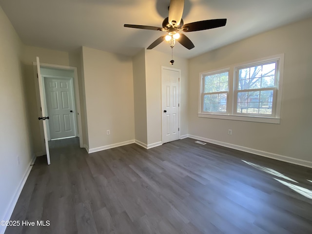 unfurnished bedroom with ceiling fan, dark wood-type flooring, visible vents, and baseboards