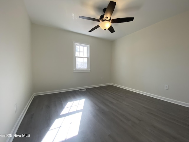 spare room featuring dark wood finished floors, baseboards, and ceiling fan