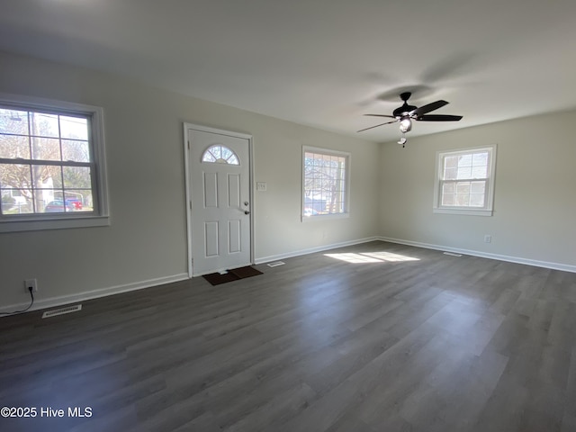 foyer entrance with plenty of natural light, dark wood finished floors, visible vents, and baseboards