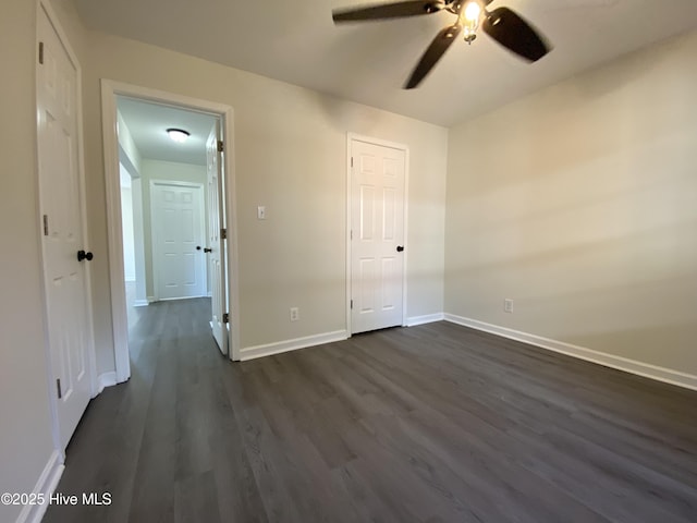 unfurnished bedroom with dark wood-style floors, baseboards, and a ceiling fan