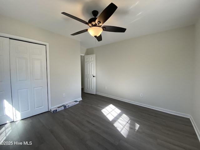 unfurnished bedroom featuring ceiling fan, dark wood-style flooring, a closet, and baseboards