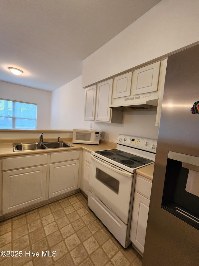 kitchen featuring white appliances, a sink, under cabinet range hood, and light floors