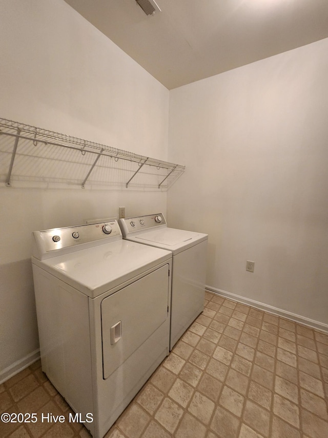 clothes washing area with baseboards, laundry area, light floors, and washer and dryer