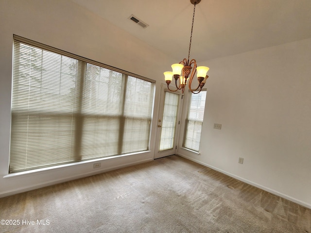 unfurnished dining area with carpet flooring, visible vents, baseboards, and an inviting chandelier