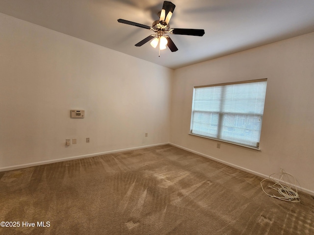 unfurnished room with a ceiling fan, carpet, and baseboards